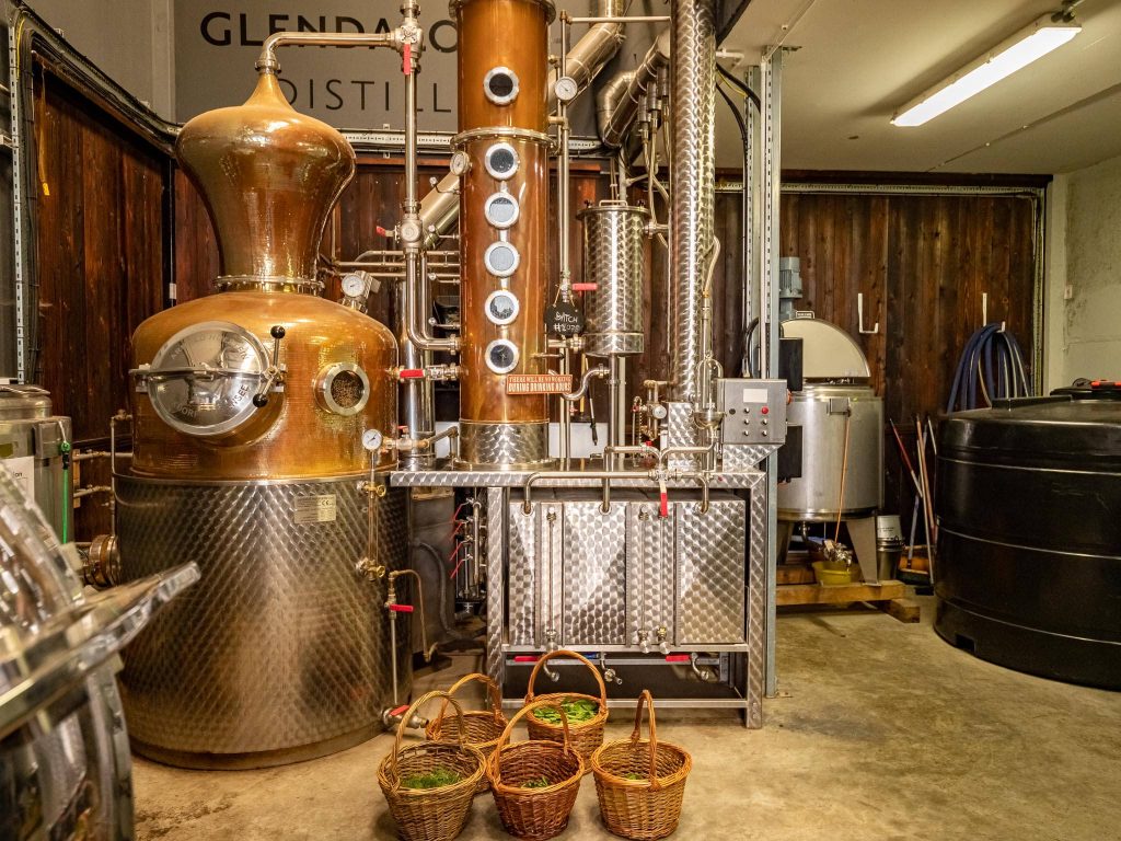 Copper and stainless steel gin still in Glendalough Distillery with fresh botanicals baskets Wallpaper