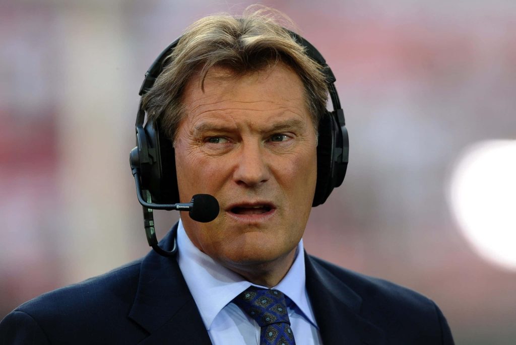Glenn Hoddle football expert commentator focused in suit with headset live sports broadcast image Wallpaper