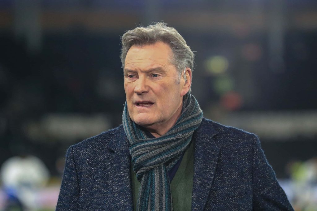 Glenn Hoddle football commentator in blue coat and scarf with blurred stadium background wallpaper
