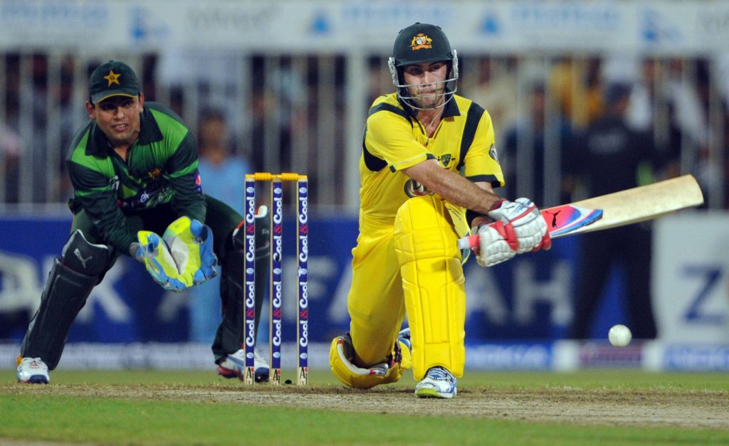 Glenn Maxwell reverse sweep cricket shot in yellow kit against Pakistani wicketkeeper wallpaper