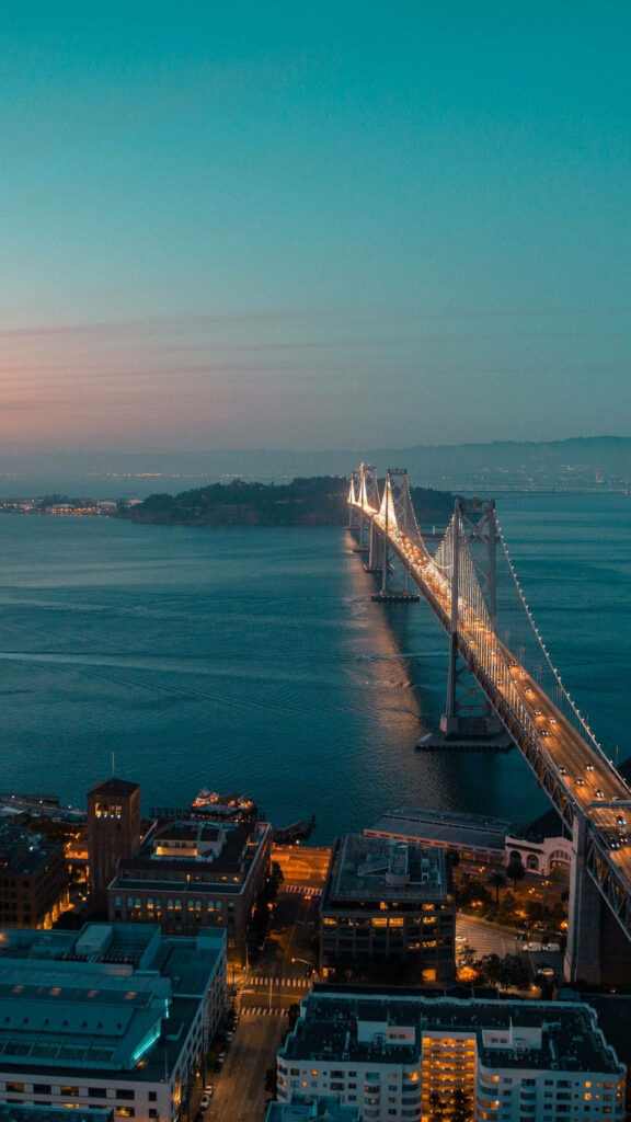 Golden Glow: Illuminated San Francisco Skyline and Hazy Golden Gate Bridge - Stunning iPhone Background Wallpaper