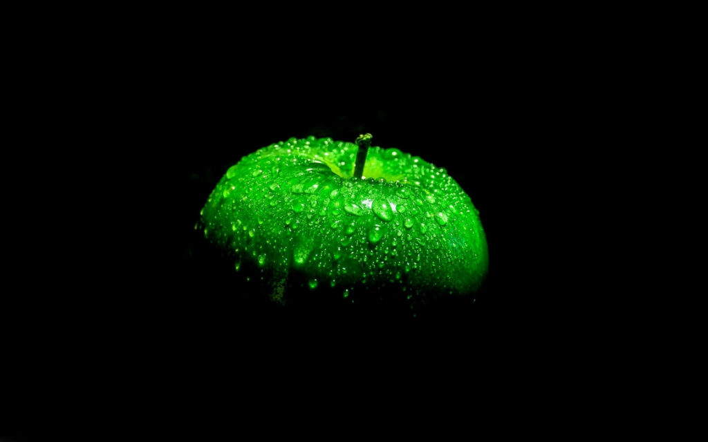 Glistening Fresh Green Apple on a Jet Black Canvas Wallpaper