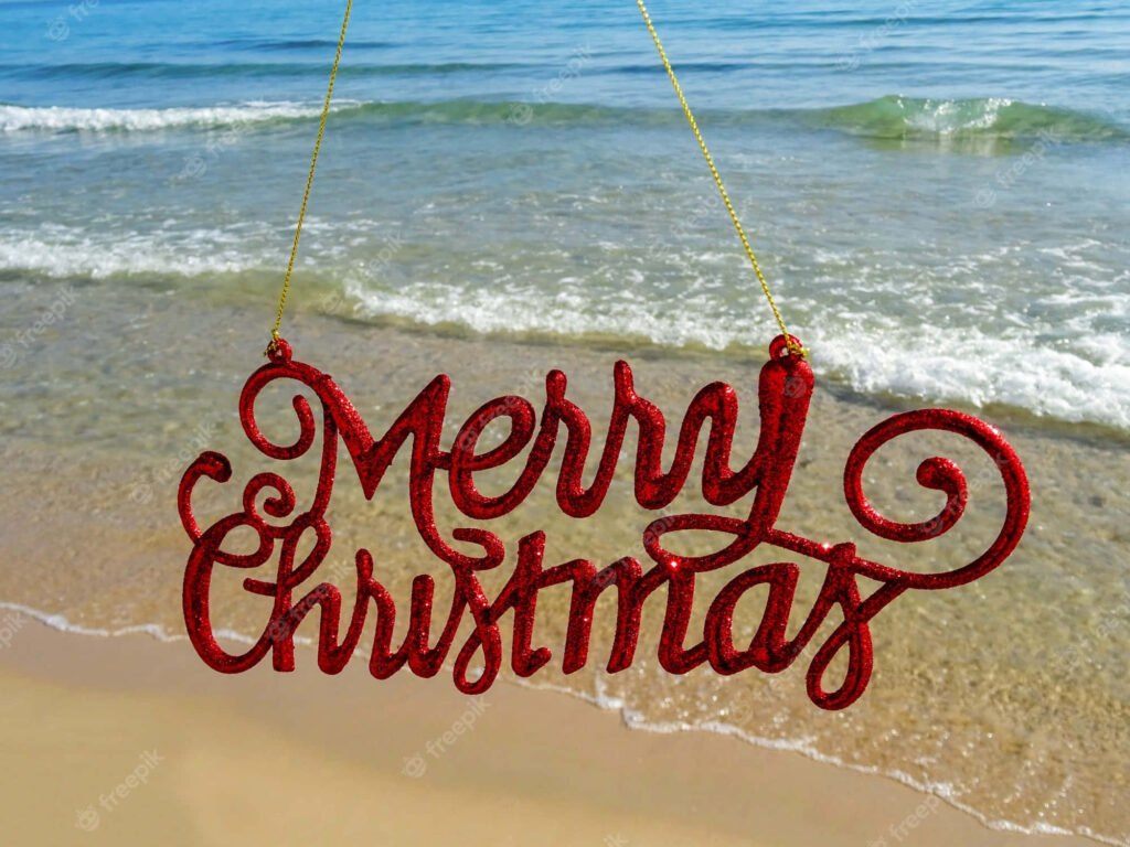 Glittery Red Merry Christmas Sign on Tranquil Beach Background Wallpaper