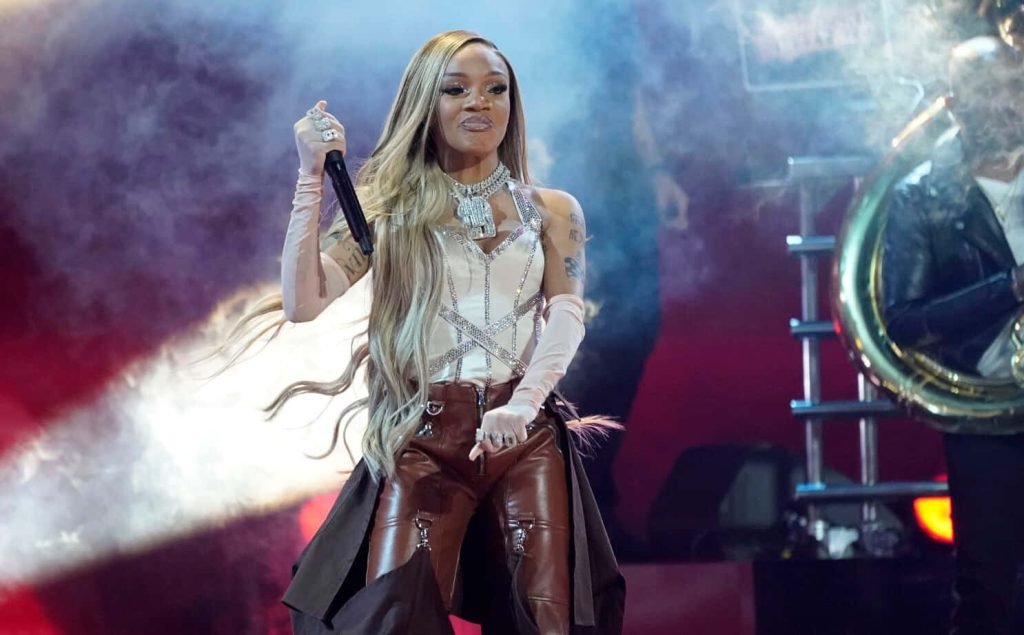 Rapper GloRilla performing live in rhinestone corset and leather pants on smoky stage Wallpaper