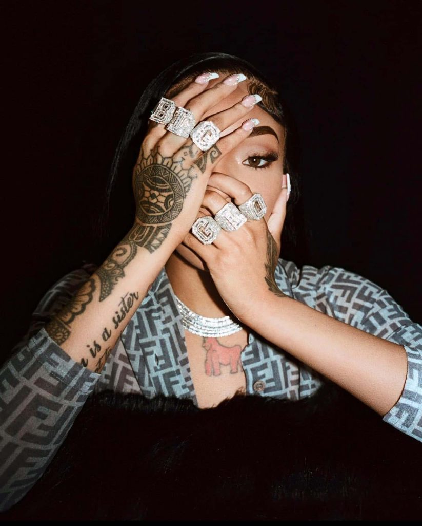 GloRilla portrait wallpaper with hand tattoos diamond rings dark background urban style flair