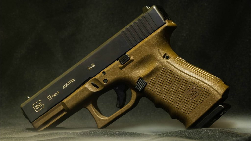 Glock 19 Gen 4 with black slide and bronze polymer frame on dark textured background wallpaper