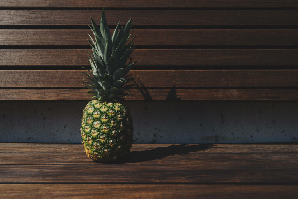 Stillness Unveiled: Pineapple Serenity Amidst Bench's Rustic Charm Wallpaper