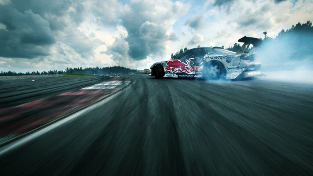 Dramatic Drift: Jaw-Dropping Racing Car Captured in Action Against Brooding Skyline Wallpaper