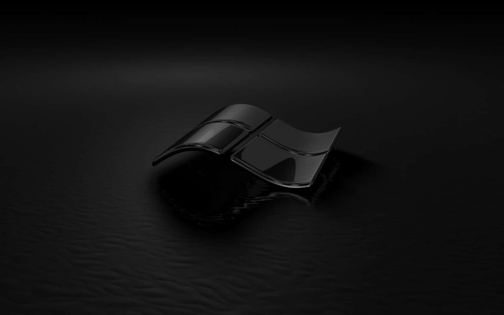 Glossy 3D Windows logo on dark textured reflective surface sleek minimalist black wallpaper background