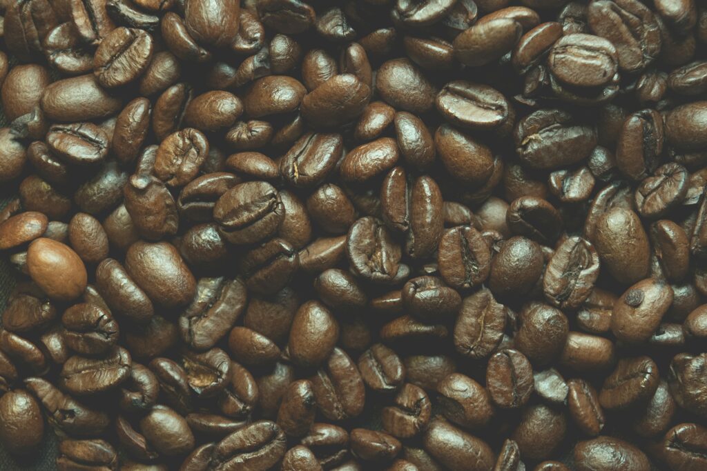Glossy Brown Coffee Beans Macro: Detailed Wallpaper Background