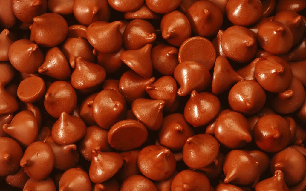 Indulge in Glossy Chocolate Drops - Tempting Wallpaper Background
