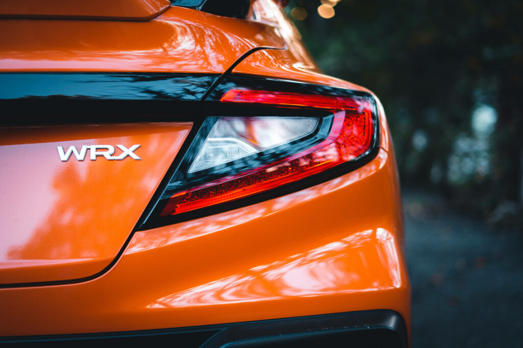 Glossy orange Subaru WRX STI close-up showing sleek tail light design and bold sporty style Wallpaper
