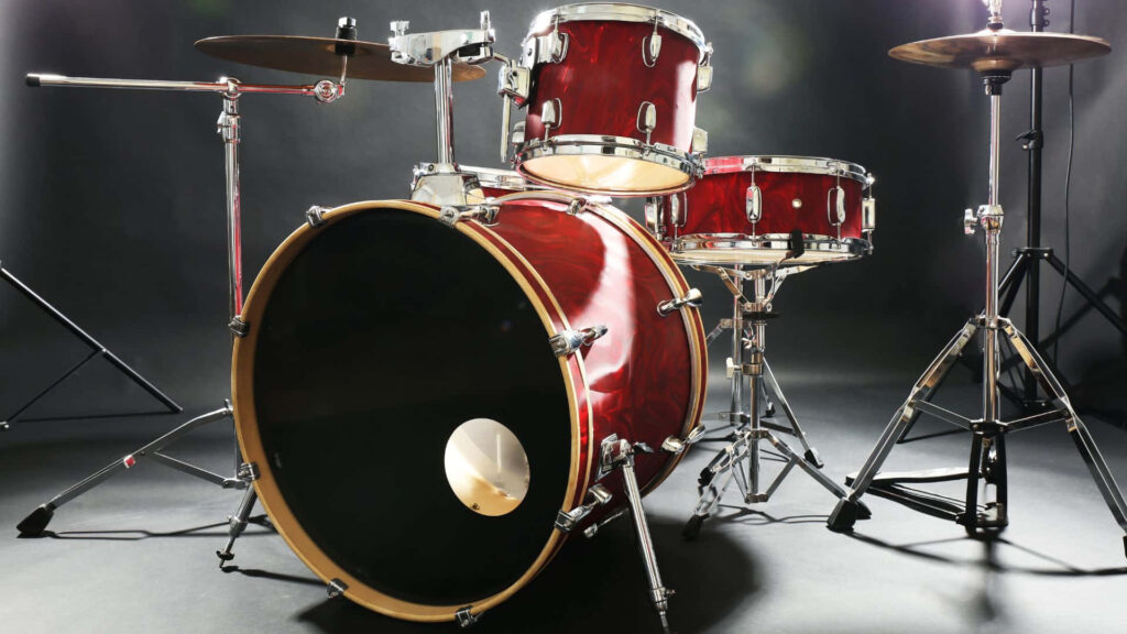 Glossy red drum kit with cymbals and chrome hardware under studio lighting wallpaper background