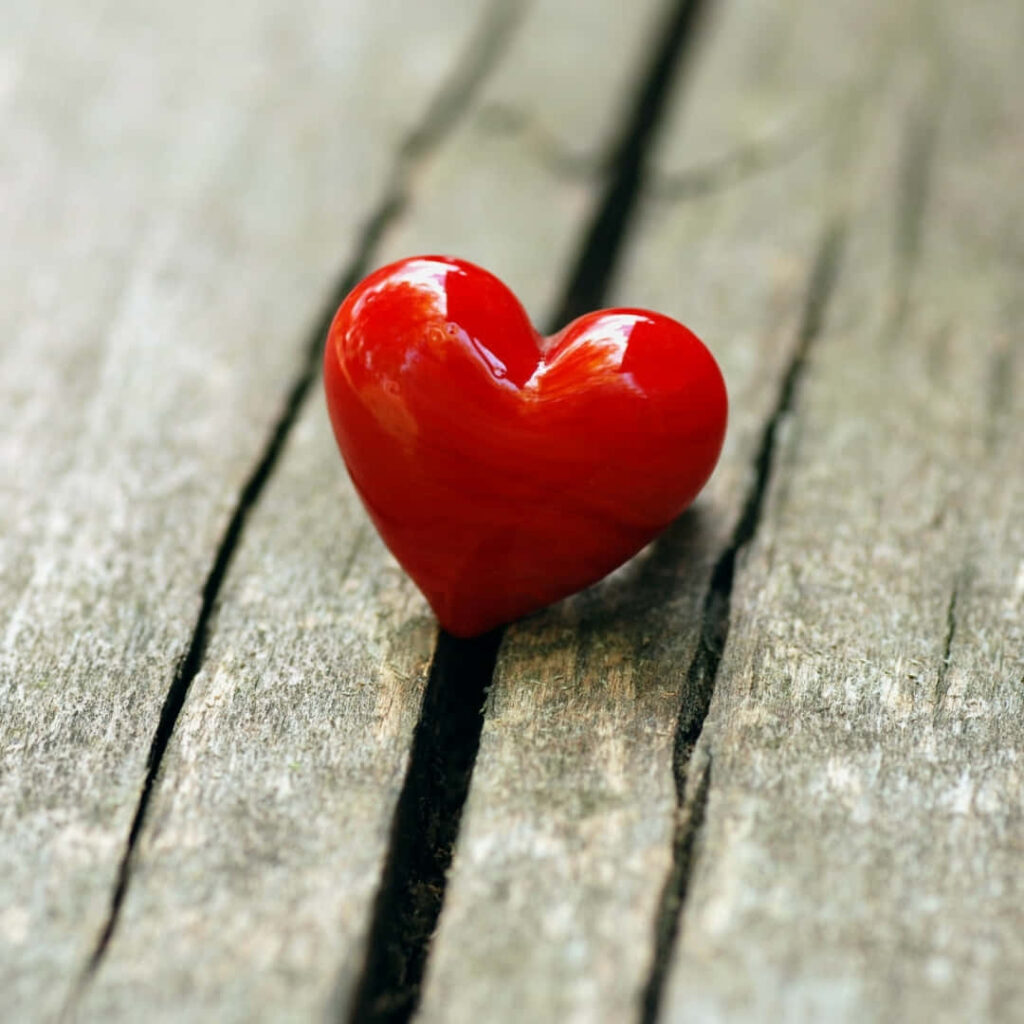 Glossy Red Heart Wallpaper on Rustic Wood - Simple Charm Background