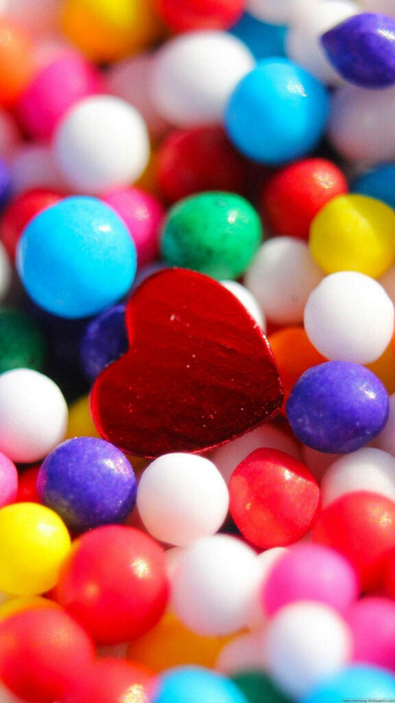 Vibrant iPhone Wallpaper: Glossy Red Heart Amid Colorful Candy Spheres