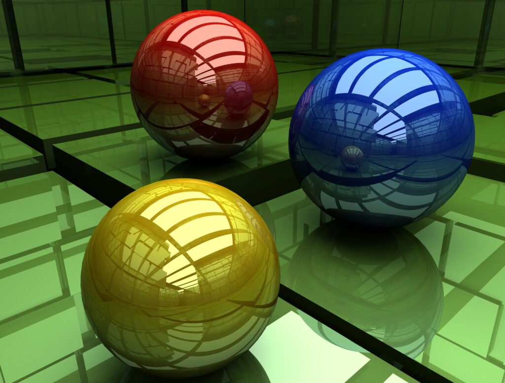 Glossy Three-Colored Spheres on Reflective Green Surface Wallpaper