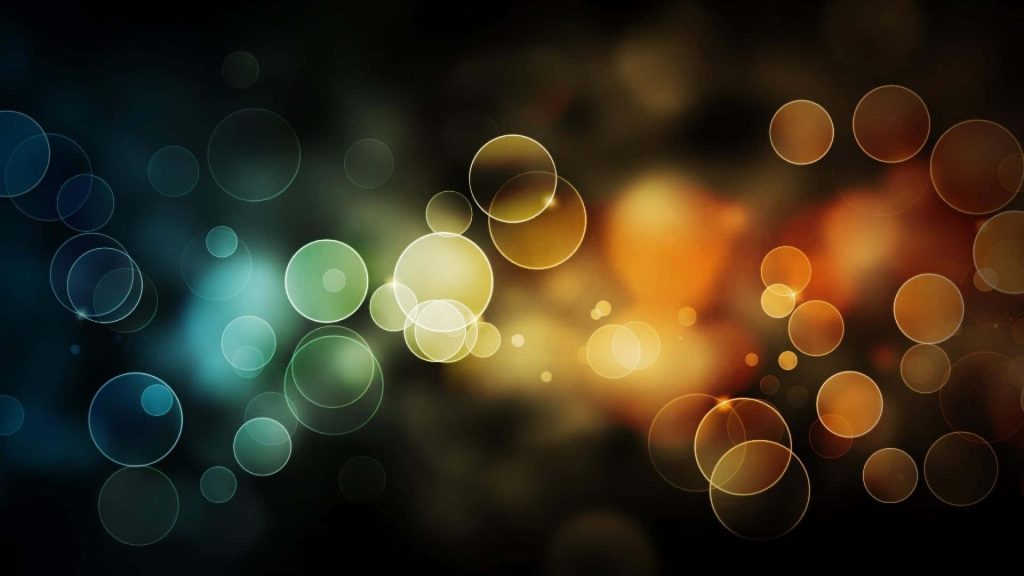 Abstract bokeh circles wallpaper with teal to amber gradient on dark background for desktop