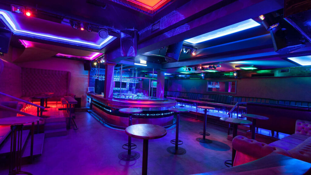 Glowing Ambiance: Mesmerizing Neon Lights Illuminate a Lively Pub Restaurant Wallpaper