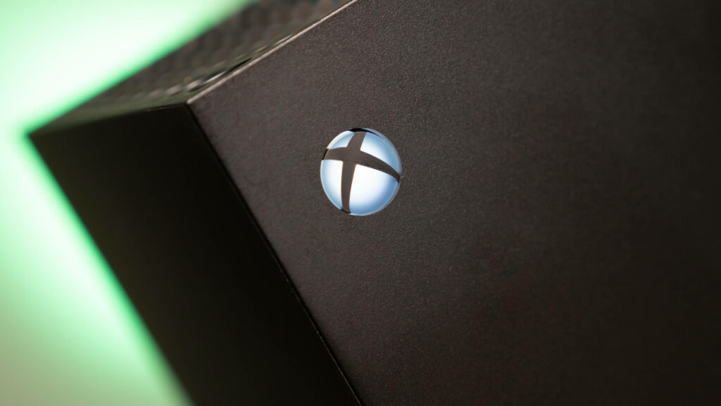 Glowing Blue Emblem: A Close-up of Xbox Series X Console's Distinctive Logo Wallpaper