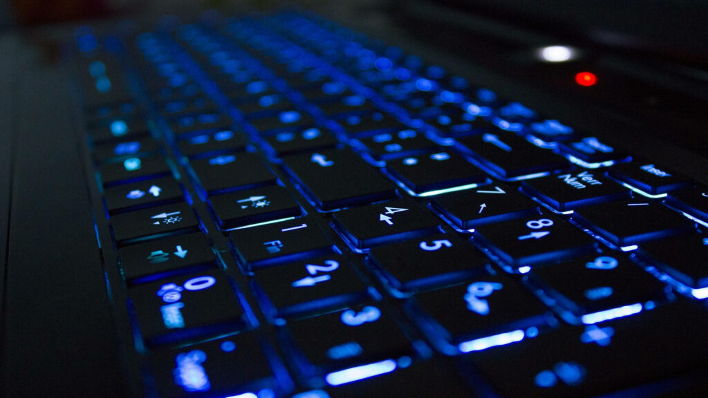 Sleek Blue Back Lit Keyboard in a Modern Computer Setup Wallpaper