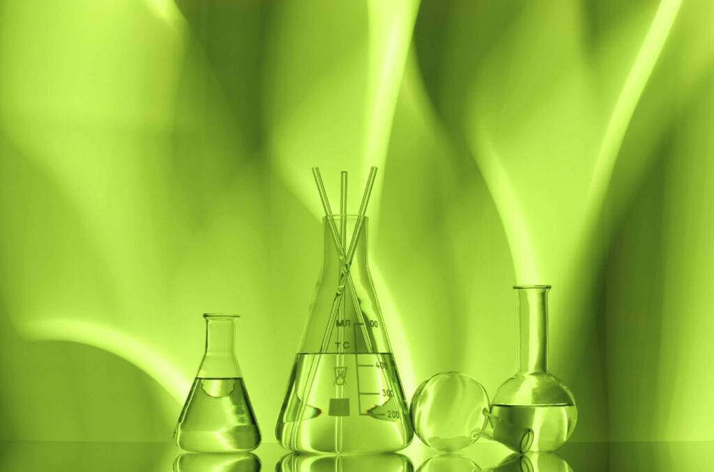 Chemistry wallpaper with glass beakers and flasks on vibrant glowing green scientific background