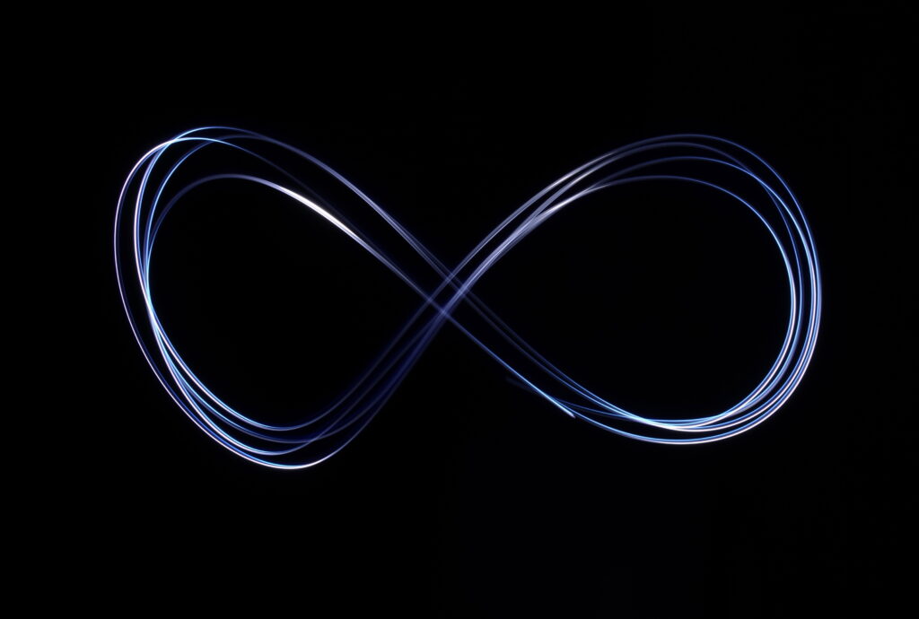 Glowing Infinity Symbol Wallpaper: Light Painting on Dark Background