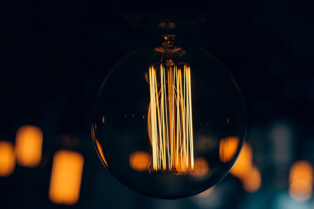 Warm Glowing Light Bulb Detailed Filament Wallpaper Background