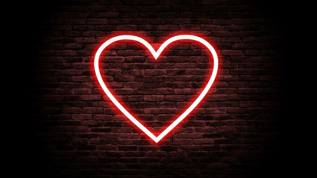 Glowing Love: A Captivating Neon Heart Against Rustic Brick Wallpaper