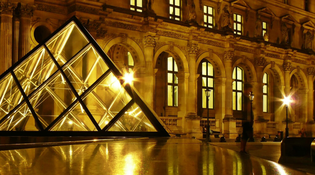 Glowing Pyramid Structure at Night: Urban Wallpaper with Historic Details