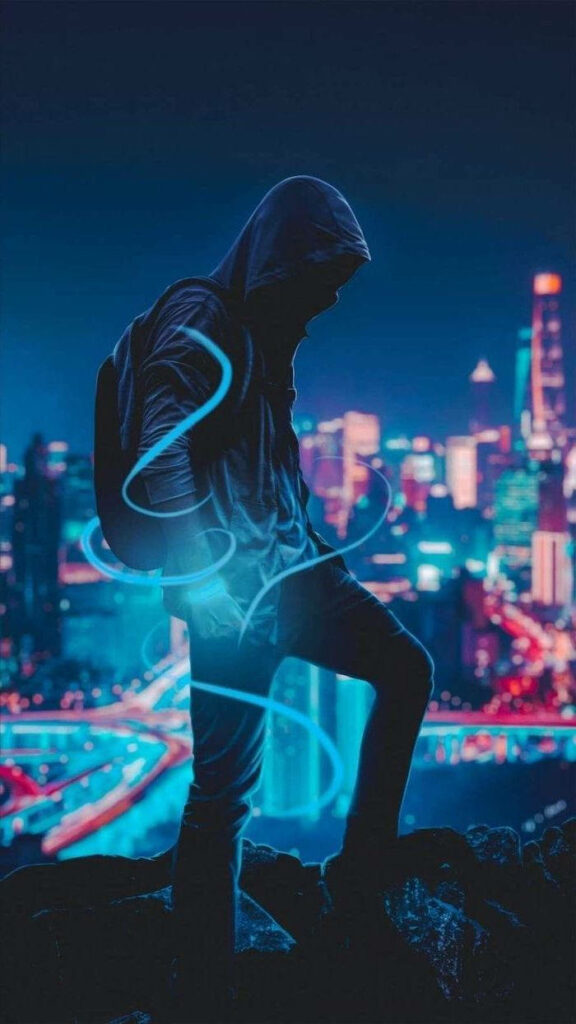 Hooded Man's Mesmerizing Glow: City Skyline as Stylish Backdrop Wallpaper
