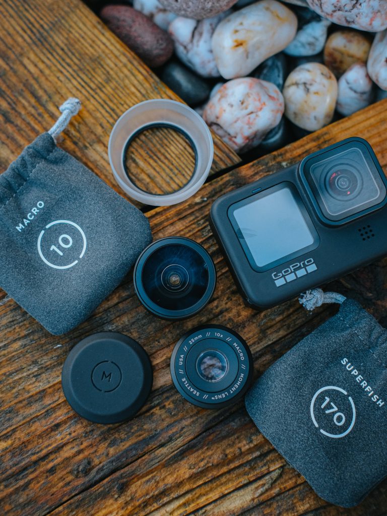 Flat lay of GoPro with Moment 25mm Macro 10x and Superfish lenses on rustic wood background Wallpaper
