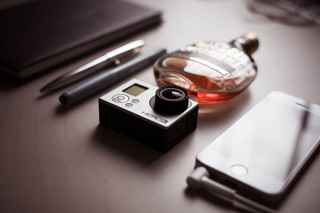 GoPro HERO3 camera and Diesel Fuel for Life perfume on stylish desktop with smartphone pens notebook Wallpaper