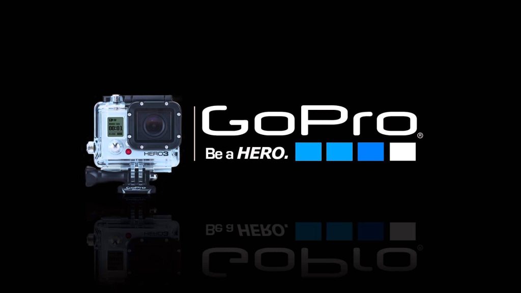 GoPro Hero3 camera in waterproof housing with logo and Be a HERO slogan on black background Wallpaper