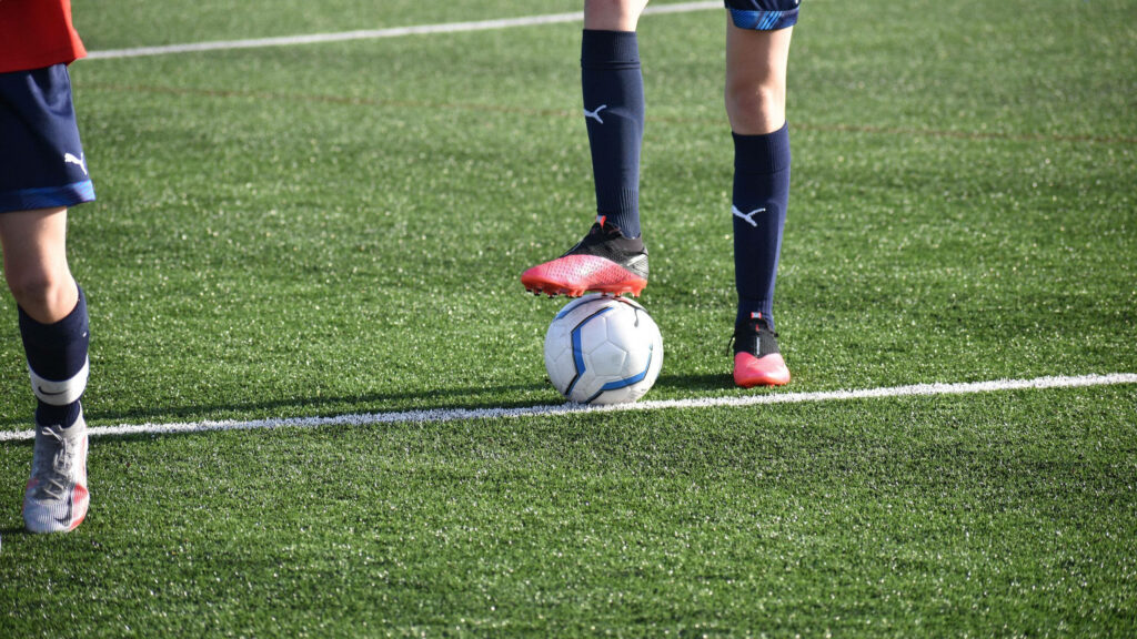 Precision in Play: A Soccer Player's Strategic Move on the Field - 2560x1440 Soccer Background Photo Wallpaper