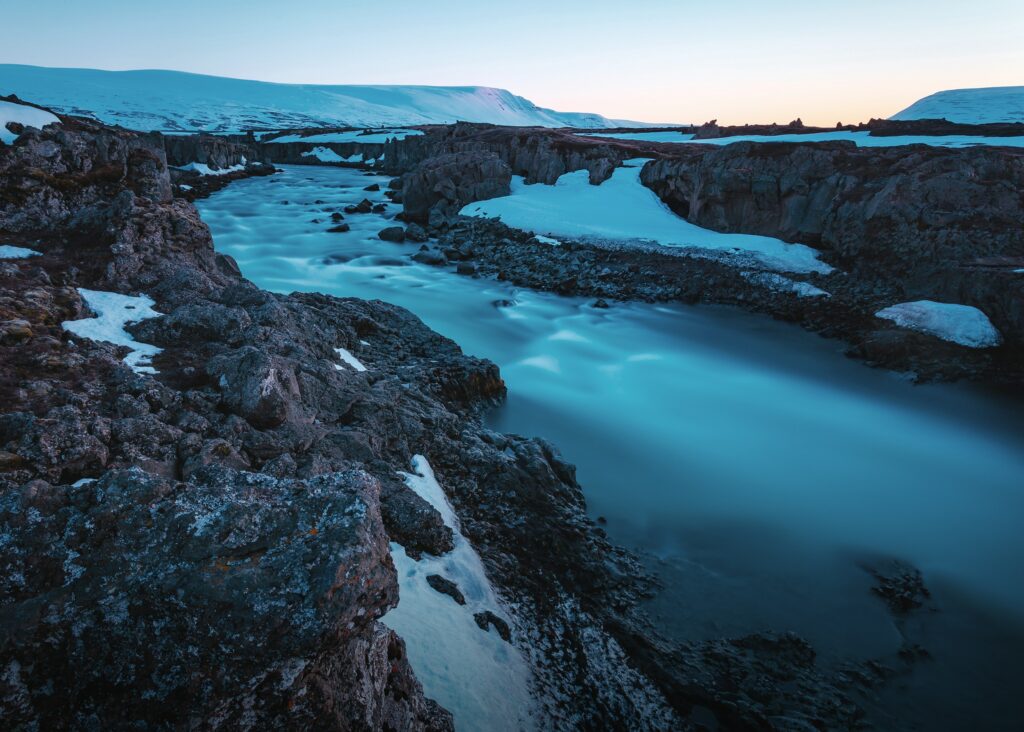 Godafoss waterfall Iceland icy blue waters volcanic rocks snow-capped twilight long-exposure Wallpaper