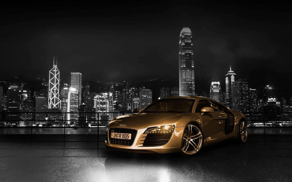Gold Audi R8 parked at night with vibrant city skyline luxury sports car wallpaper background