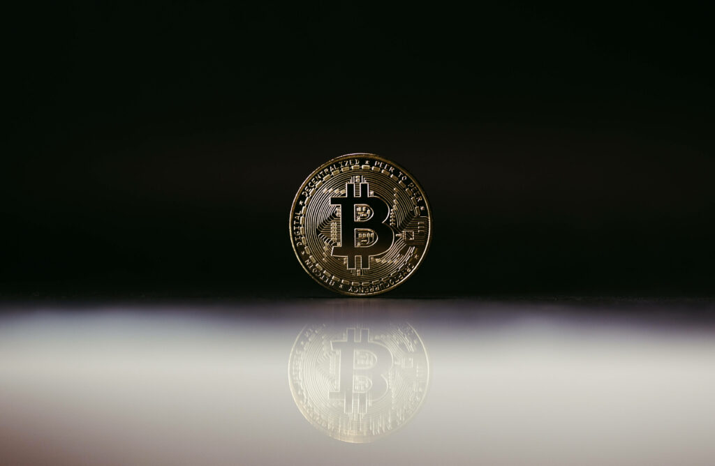 Gold Bitcoin symbol on sleek black background modern cryptocurrency wallpaper design