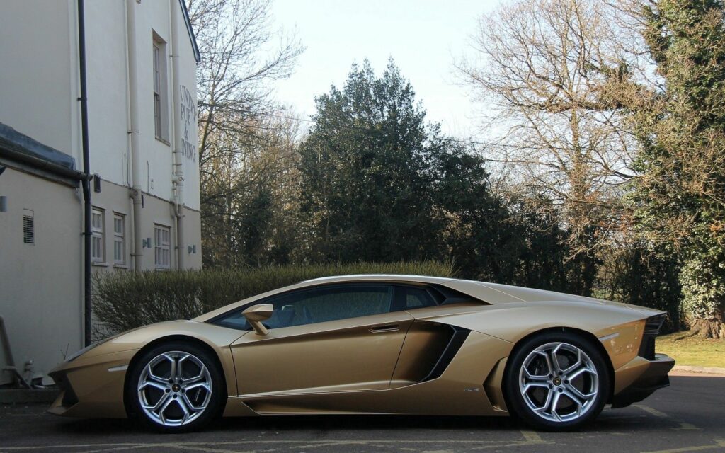 Elegant Gold Lamborghini Aventador in Suburban Profile View Wallpaper