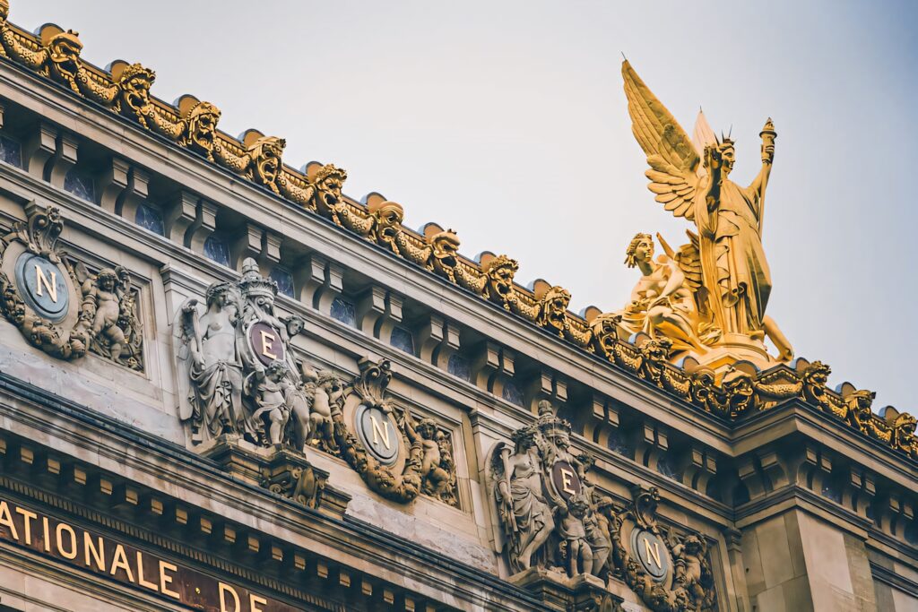 Golden angel statue on ornate classical building with detailed architecture wallpaper background
