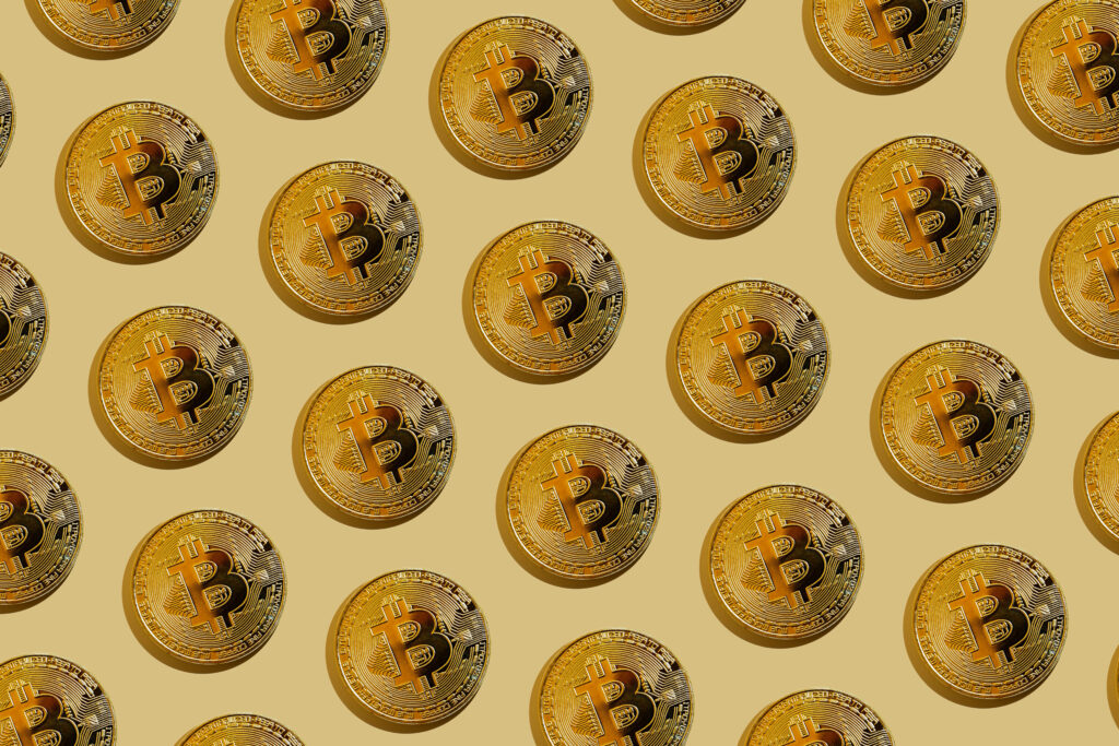 Repeating golden Bitcoin coins pattern on beige background modern cryptocurrency wallpaper