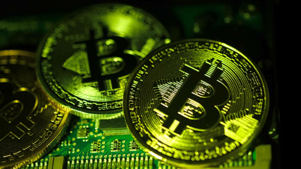 Golden Bitcoins on glowing green motherboard digital currency crypto technology background Wallpaper