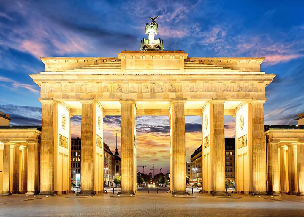 Golden Brandenburg Gate illuminated at sunset with blue sky showcasing neoclassical architecture Wallpaper