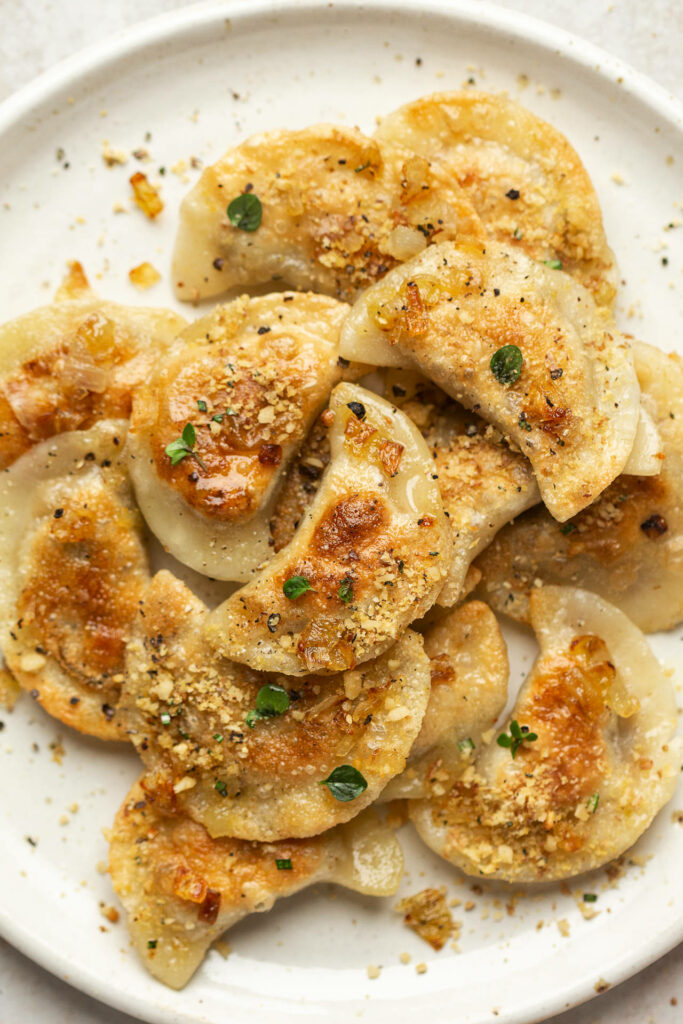 Delicious Golden Fried Pierogi with Herbs: Elegant Wallpaper Background