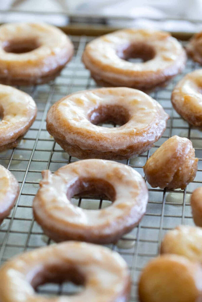 Golden brown glazed donuts on cooling rack with shiny sugar glaze soft texture wallpaper