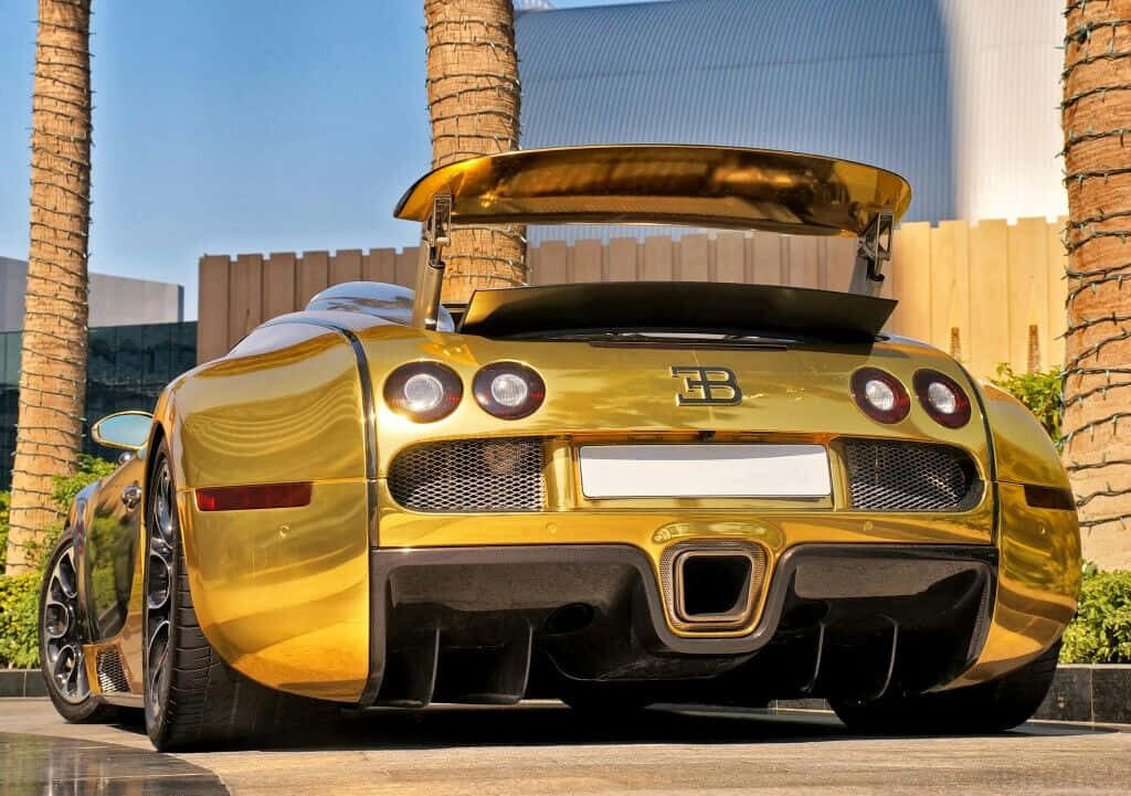 Gold Bugatti Veyron outdoors reflecting sunlight with trees and modern buildings background wallpaper