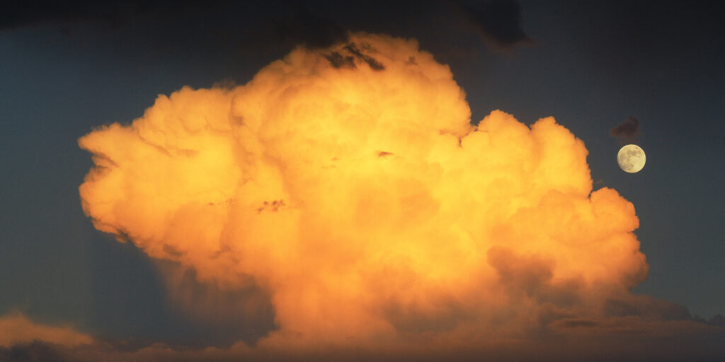 Golden glowing cloud at sunset with bright full moon rising in dramatic evening sky wallpaper
