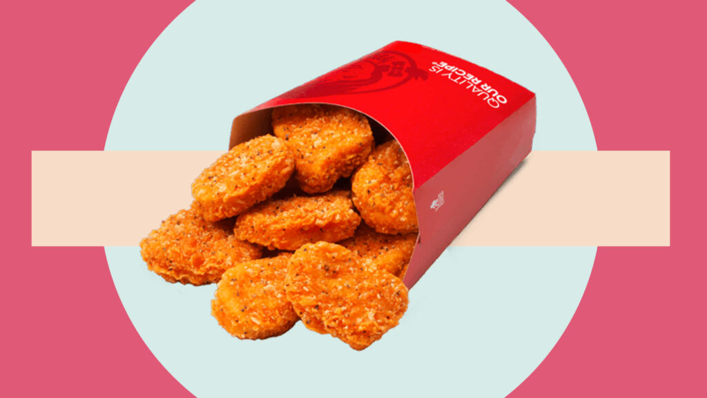 Red box filled with crispy golden chicken nuggets on colorful vibrant fast food wallpaper background