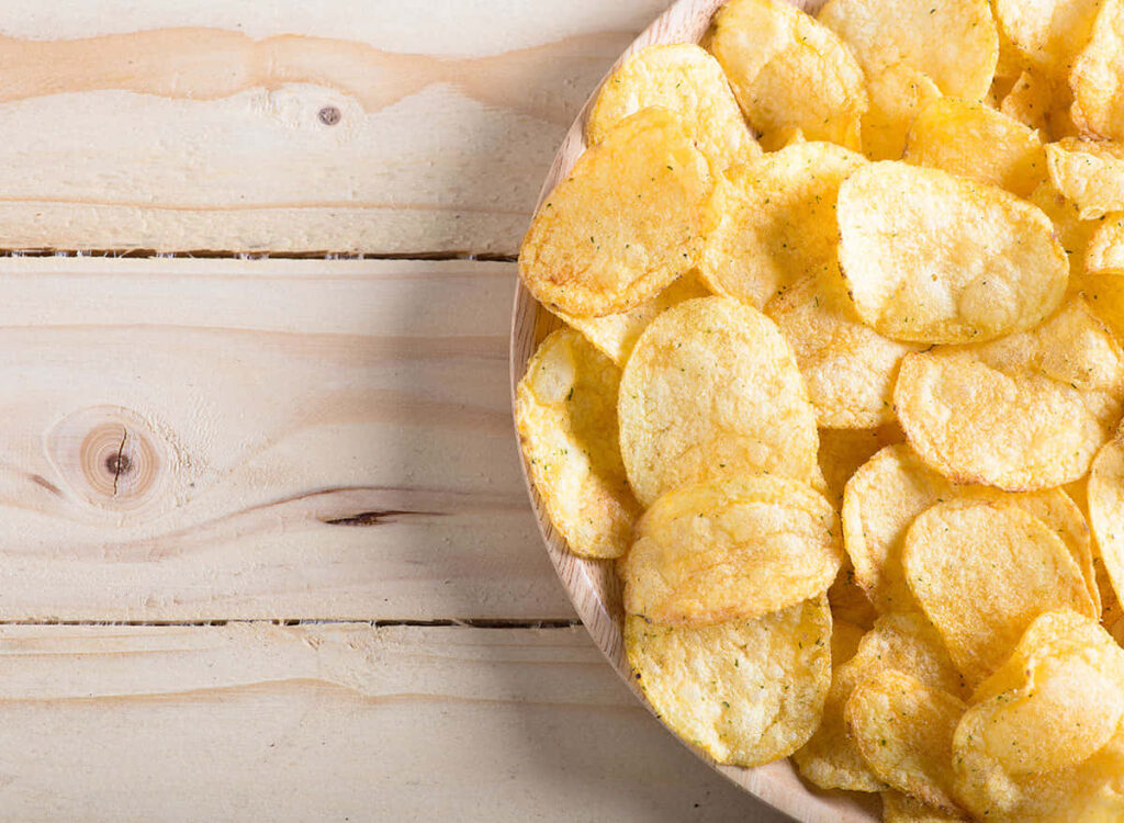 Crispy Golden Flat Chips on Rustic Wood - Appetizing Wallpaper