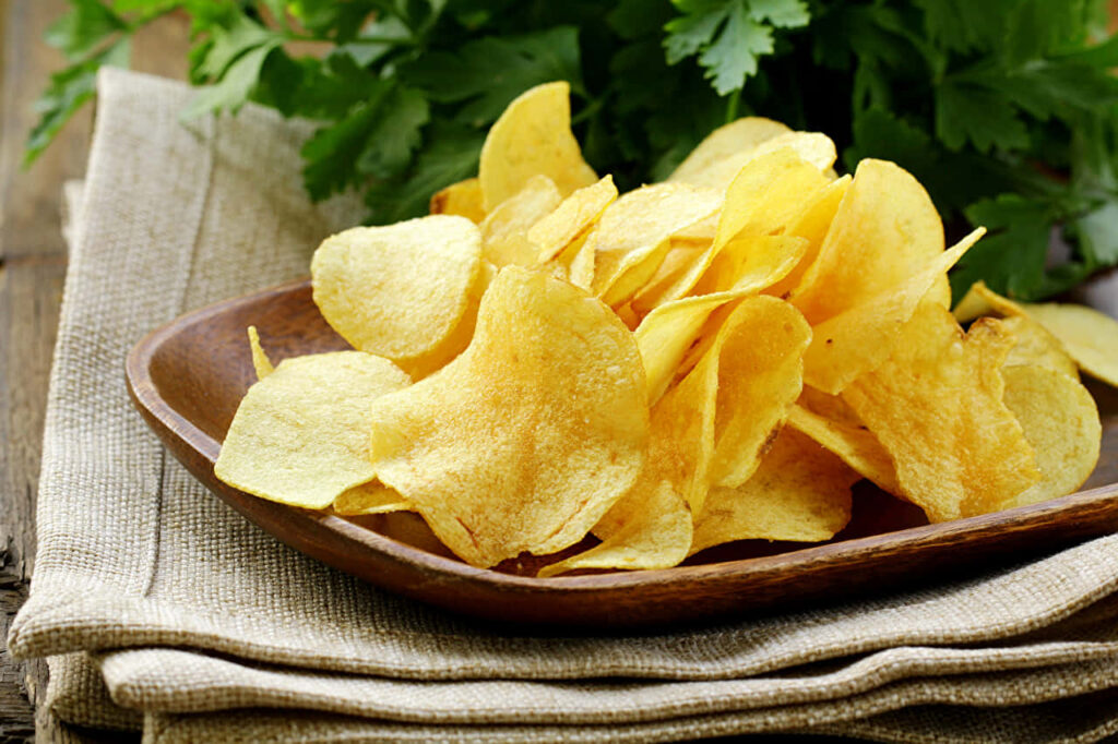 Golden Crispy Potato Chips in Rustic Brown Plate - Wallpaper Background