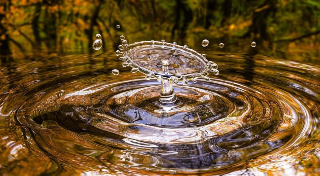 Macro photo of golden water drop crown splash with warm autumn tones and sharp liquid motion Wallpaper